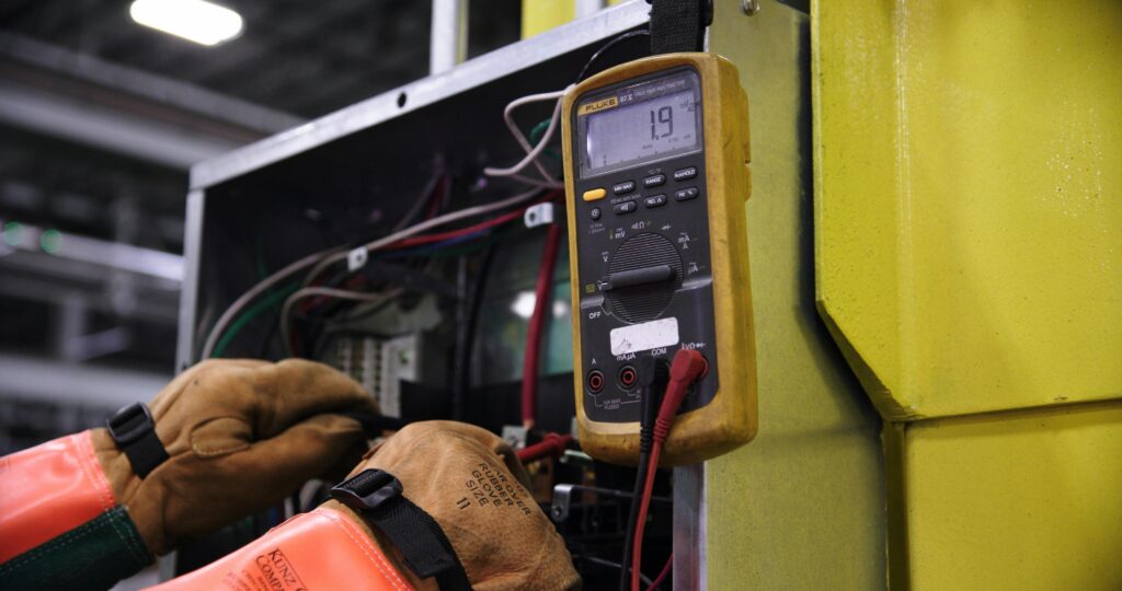 Pexels photo 14319099 14319099 Electrician using a multimeter to fix industrial control panel wiring.
