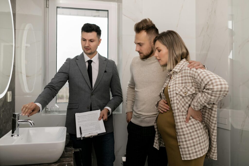 Pexels photo 7641897 7641897 Real estate agent demonstrates bathroom features to a young couple during a house tour.