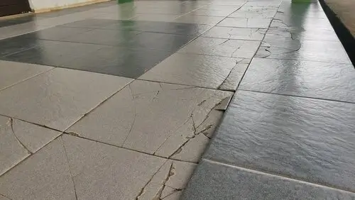 Cracked and uneven floor tiles showing poor tile installation and surface leveling defects in a residential property.